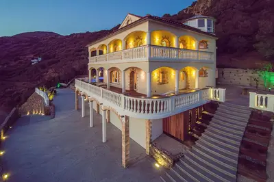 a large house with a staircase leading up to it at Villa Sun Rock - Ravdoucha in Kolymvari