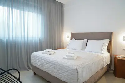 a bedroom with a large bed with two towels on it at Niki Luxury Suites Pool Resort 200m From Beach in Chorafakia