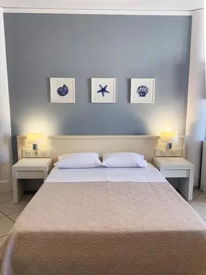 a bedroom with a large bed with two nightstands and two lamps at Platanias Memories Studio 5 in Plataniás