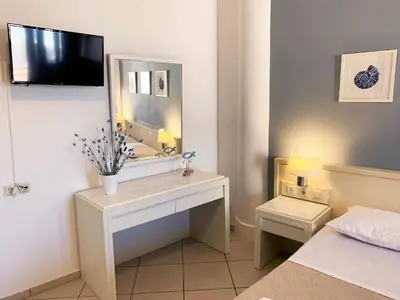 a bedroom with a desk with a mirror and a bed at Platanias Memories Studio 5 in Plataniás