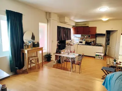 a living room with a table and a kitchen at Lovely small apartment in Chania Town