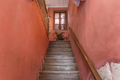 a staircase in an orange hallway with a window at Full House in Chania Town