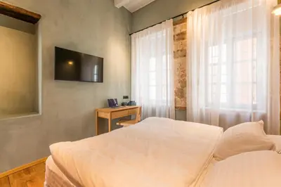 a bedroom with a bed and a television on the wall at Full House in Chania Town
