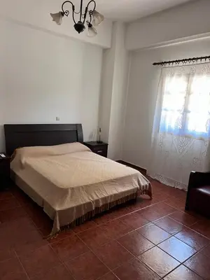 a bedroom with a large bed and a window at Tzortzinas Cottage in Chania Town