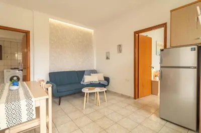 a living room with a blue couch and a refrigerator at Dream Apartments 3 in Palaiochóra