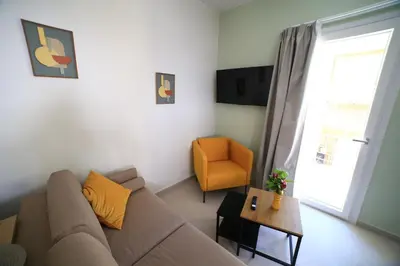 a living room with a couch and a chair at GREEN n' BLUE apartments in Kalamaki Chanion