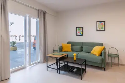 a living room with a green couch and a table at GREEN n' BLUE apartments in Kalamaki Chanion