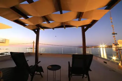 a balcony with chairs and a view of the water at GREEN n' BLUE apartments in Kalamaki Chanion