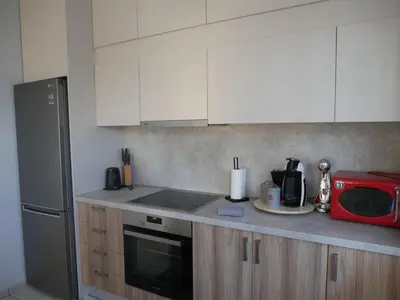 a kitchen with white cabinets and a red microwave at Gio's Central Cosy Apartment with private balcony in Chania Town