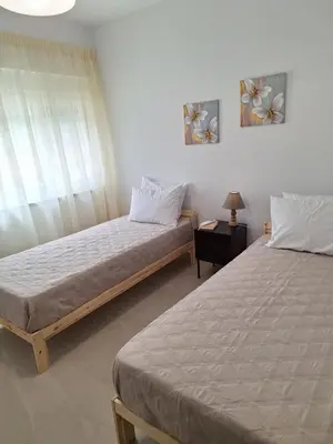 a bedroom with two beds and a lamp on a table at Iris&Phaedra in Ayiá