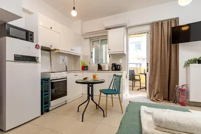a kitchen with white cabinets and a table in a room at Koum Kapi Mare Studios C2 in Chania Town