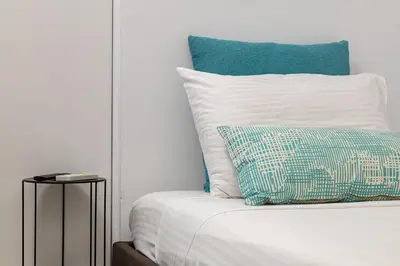 a bed with a blue and white pillow on it at Koum Kapi Mare Studios C2 in Chania Town