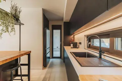 a kitchen with black cabinets and a sink at Nos Aqua Villas Chania in Pazinos