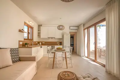 a kitchen and living room with a couch and a table at Superior Argilos Cottage Private Pool - 300m From the beach in Korfalónas