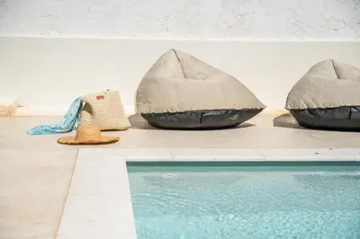 two bean bags sitting next to a swimming pool at Superior Argilos Cottage Private Pool - 300m From the beach in Korfalónas