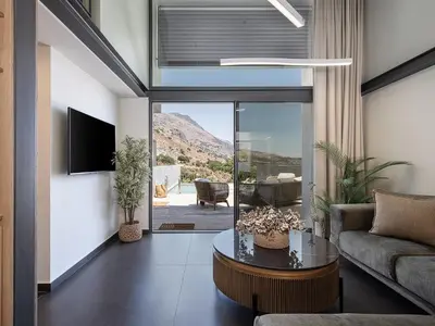 a living room with a couch and a table at Nature's Den in Frangokastello