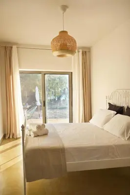 a bedroom with a large bed and a large window at Mekia's beach house in Livadia