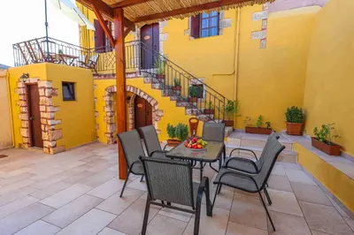 a patio with a table and chairs in front of a building at SternesVillage, Lower Ground Floor in Stérnai