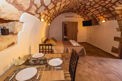 a room with two beds and a table with plates on it at SternesVillage, Lower Ground Floor in Stérnai