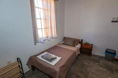 a small bedroom with a bed and a window at SternesVillage, Premium Balcony Suite in Stérnai