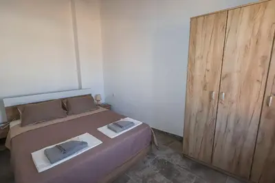 a bedroom with a bed and a wooden cabinet at SternesVillage, Premium Balcony Suite in Stérnai