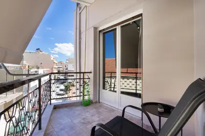 a balcony with a door and a table and chairs at Sophia Apartment in Chania Town
