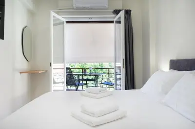 a bedroom with a white bed and a balcony at Sophia Apartment in Chania Town