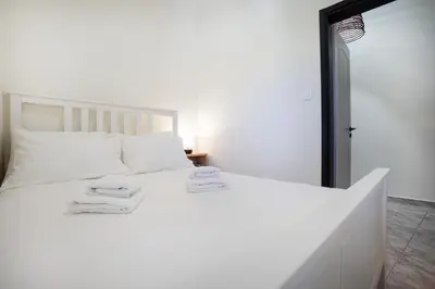 a bedroom with a white bed with two towels on it at Sophia Apartment in Chania Town