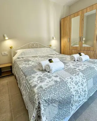 a bedroom with two beds with towels and a mirror at Christina & Suzan Apartment in Chania Town