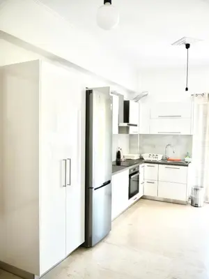 a kitchen with white cabinets and a refrigerator at Kouklospito in Chania Town