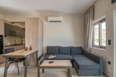 a living room with a blue couch and a table at Vissalo Studios in Kissamos