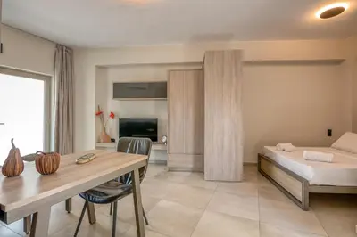 a bedroom with a bed and a desk and a table at Vissalo Studios in Kissamos