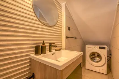 a bathroom with a sink and a washing machine at Vissalo Studios in Kissamos