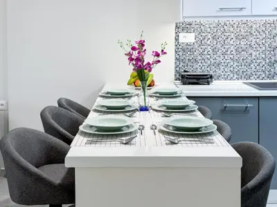 a table with chairs and plates and a vase of flowers at All Seasons Luxury Apartment in Chania Town