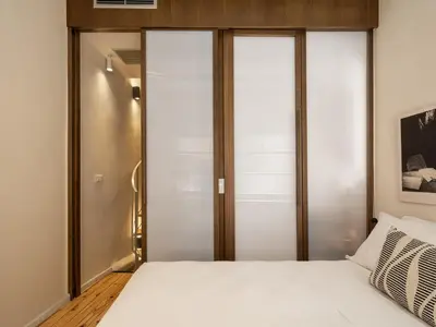 a bedroom with a white bed and sliding glass doors at Green Lilly Home in Chania Town