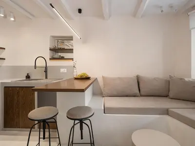 a kitchen and living room with a couch and stools at Green Lilly Home in Chania Town