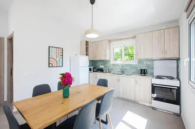 a kitchen with a wooden table with a vase of flowers on it at Peponas Residence in Kato Daratso
