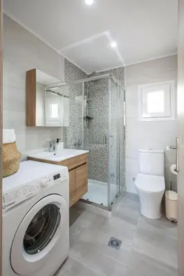 a bathroom with a washing machine and a toilet at Peponas Residence in Kato Daratso