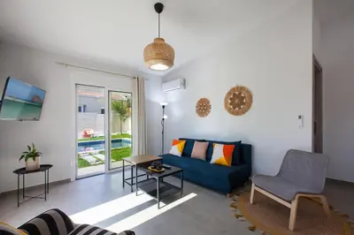 a living room with a blue couch and a table at Peponas Residence in Kato Daratso