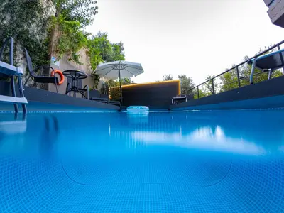 a swimming pool with blue water and an umbrella at Blissful Residence with Pool by 8essentially in Daratso