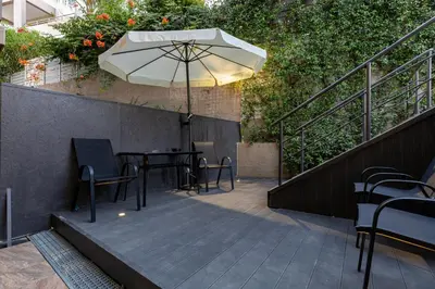 a patio with a table and an umbrella at Blissful Residence with Pool by 8essentially in Daratso