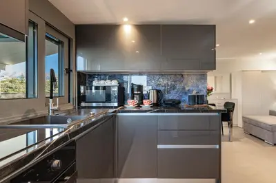 a kitchen with stainless steel appliances and a large window at Panorama View Apt with Jacuzzi by 8essentially in Daratso
