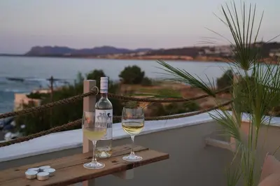 a bottle of wine and two glasses on a table at Porta Harenae Residencia in Chania Town
