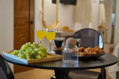 a table with a plate of bread and glasses of wine at Porta Harenae Residencia in Chania Town