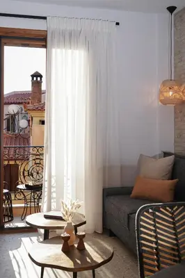 a living room with a couch and a balcony at Porta Harenae Residencia in Chania Town
