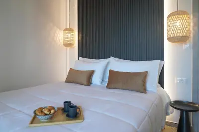 a white bed with a tray of food on it at Porta Harenae Residencia in Chania Town