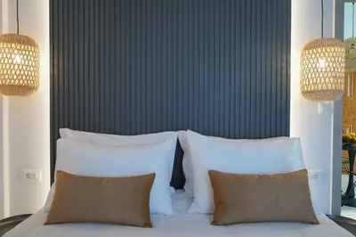 a bedroom with white pillows and a blue wall at Porta Harenae Residencia in Chania Town
