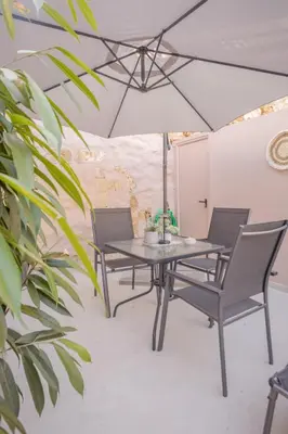 a dining table and chairs with an umbrella at Comfinest in Chania Town