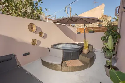a patio with a hot tub and an umbrella at Comfinest in Chania Town