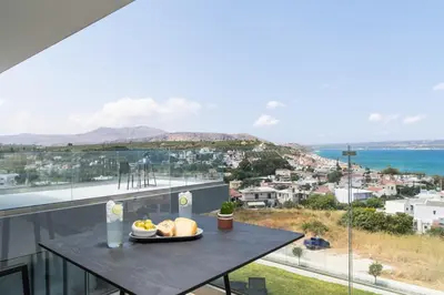 a table with a plate of food on top of a balcony at Paradise Hill Luxury Villa in Kalyves